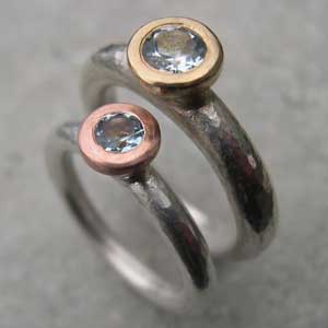 two topaz engagement rings, one with yellow gold and the tother with red gold top