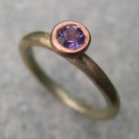 Amethyst engagement ring set in red gold on a yellow gold ring