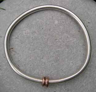 red gold bead on silver bangle