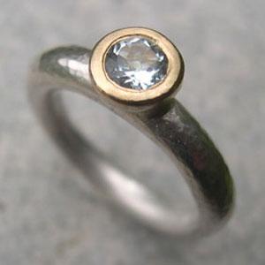 silver  engagement  ring with  topaz set in a gold pillow