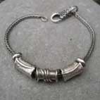 5 silver beads on a silver bracelet
